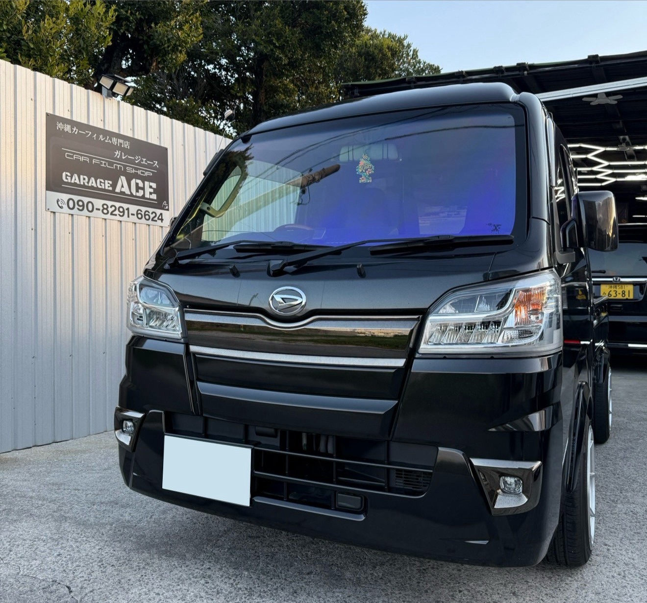 フロントガラスにカーフィルムを施工した黒い軽トラック